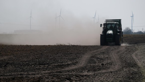 Ein Traktor bringt Dünger auf einen Acker bei Zörbig aus, wobei als Folge von Dürre und Trockenheit viel Staub aufgewirbelt wird. Am Mittwoch (30.03.2022) beginnt die Agrarministerkonferenz unter Vors ...