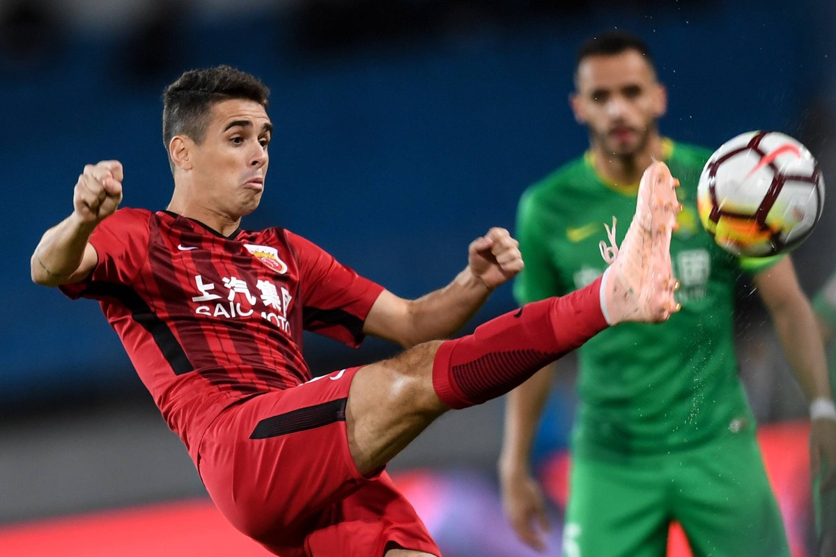 Brazilian football player Oscar, left, of Shanghai SIPG kicks against Beijing Sinobo Guoan in their 24th round match during the 2018 Chinese Football Association Super League (CSL) in Beijing, China, ...