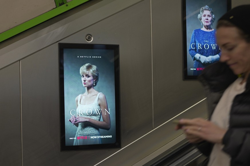 The screen shows an advertisement of the popular Netflix series &quot;The Crown,&quot; in an underground station, in London, Friday, Nov. 18, 2022. Elizabeth Emanuel has recreated a gown for the then  ...