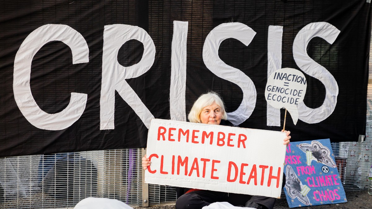 Eine Aktivistin sitzt bei einer Protestaktion der Umweltschutzbewegung Extinction Rebellion für die Todesopfer des Klimawandels vor dem Gelände der UN-Klimakonferenz COP26. In Glasgow ringen rund 200 ...