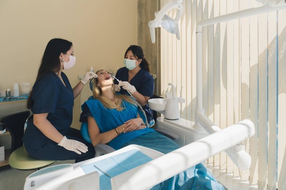 Zahnärztin untersucht die Zähne einer Patientin und führt eine zahnärztliche Untersuchung in einer Zahnklinik durch *** Dentist examined the Teeth a Patient and leads a dental Investigation in a Denta ...
