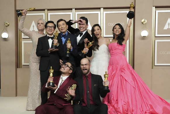 12.03.2023, USA, Los Angeles: Jamie Lee Curtis (hinten l-r), Ke Huy Quan, James Hong, Jonathan Wang, Michelle Yeoh und Stephanie Hsu, Daniel Kwan (vorne l) und Daniel Scheinert, Gewinner des Oscars fü ...