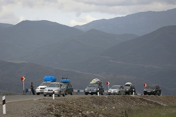 26.09.2023, Armenien, Goris: Ein Autokonvoi ethnischer Armenier aus Berg-Karabach bewegt sich nach Kornidzor . Nach der Eroberung des Gebietes Berg-Karabach durch Aserbaidschan wächst die Zahl der nac ...