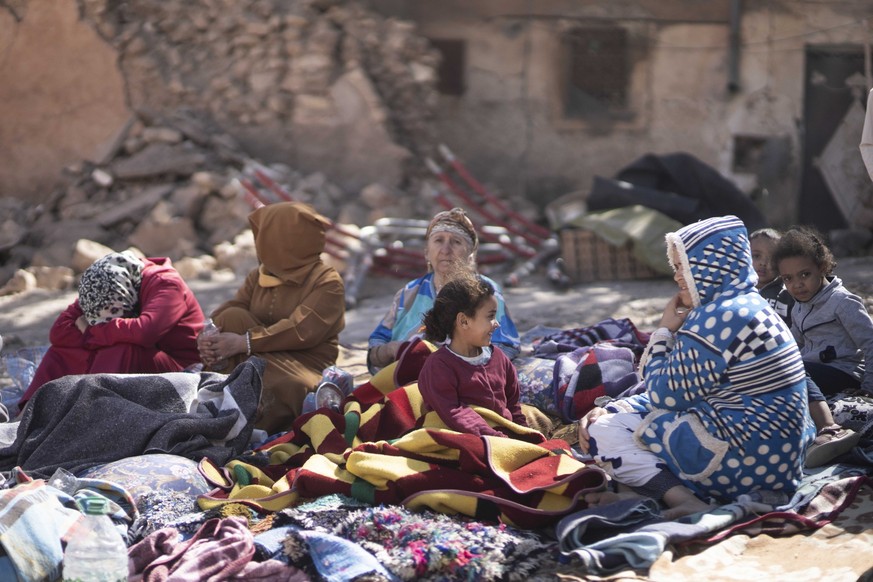 09.09.2023, Marokko, Marrakesch: Familien sitzen vor ihren zerstörten Häusern. Ein schweres Erdbeben hat Marokko erschüttert und Hunderte Todesopfer gefordert. Foto: Mosa&#039;ab Elshamy/AP/dpa +++ dp ...