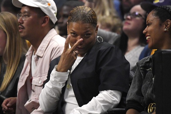 Actress/singer Dana Owens, center, also known as Queen Latifah, gestures as she watches during the second half of an NBA basketball game between the Los Angeles Clippers and the Denver Nuggets Friday, ...