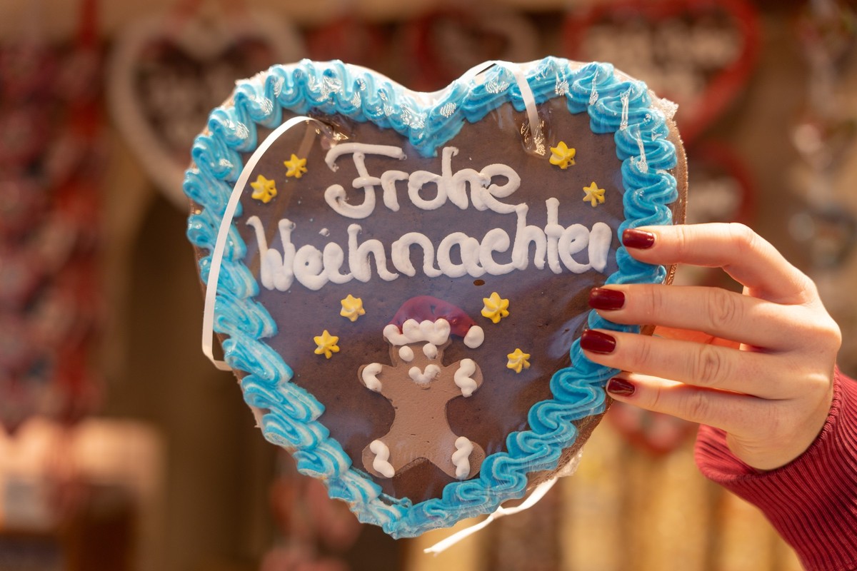 ARCHIV - 27.11.2024, Hessen, Frankfurt/Main: Eine Verkäuferin auf dem Weihnachtsmarkt in Frankfurt hält ein Lebkuchenherz mit der Aufschrift «Frohe Weihnachten» in den Händen. (zu dpa: «So laufen die  ...