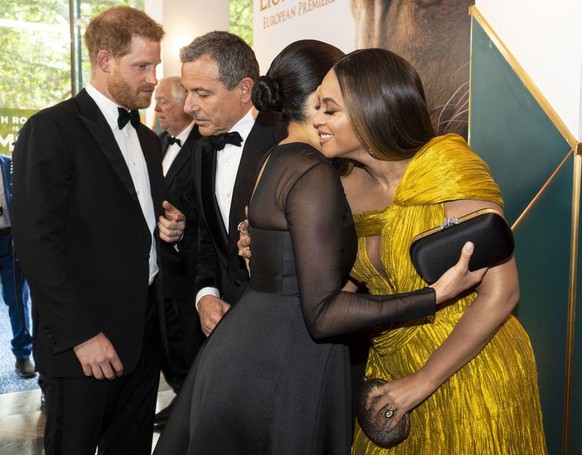 Britain's Prince Harry, Duke of Sussex (L) chats with Disney CEO Robert Iger as Britain's Meghan, Duchess of Sussex (2nd R) embraces US singer-songwriter Beyoncé (R) as they attend the European premie ...