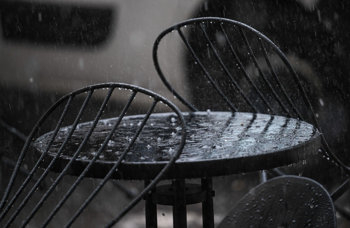 ARCHIV - 31.08.2023, Berlin: Hagel und Regen prasseln auf einen Tisch vor einem Café. (zu dpa: «DWD: Frühjahr im Saarland war extrem regnerisch - und deutlich zu warm») Foto: Britta Pedersen/dpa +++ d ...