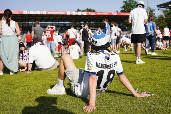 ARCHIV - 28.05.2023, Baden-Württemberg, Sandhausen: Fußball: 2. Bundesliga, SV Sandhausen - Hamburger SV, 34. Spieltag, BWT-Stadion am Hardtwald. Ein Hamburger Fan sitzt auf dem Spiellfeld.

Für das F ...