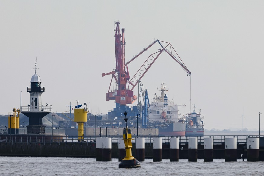 Schiffe werden be- und entladen am Hafen von Brunsbüttel. Die unmittelbare Nachbarschaft ist als Standort für ein neues LNG-Terminal (Windräder stehen vor einem Kohlelager am Elbdeich am Hafen von Bru ...