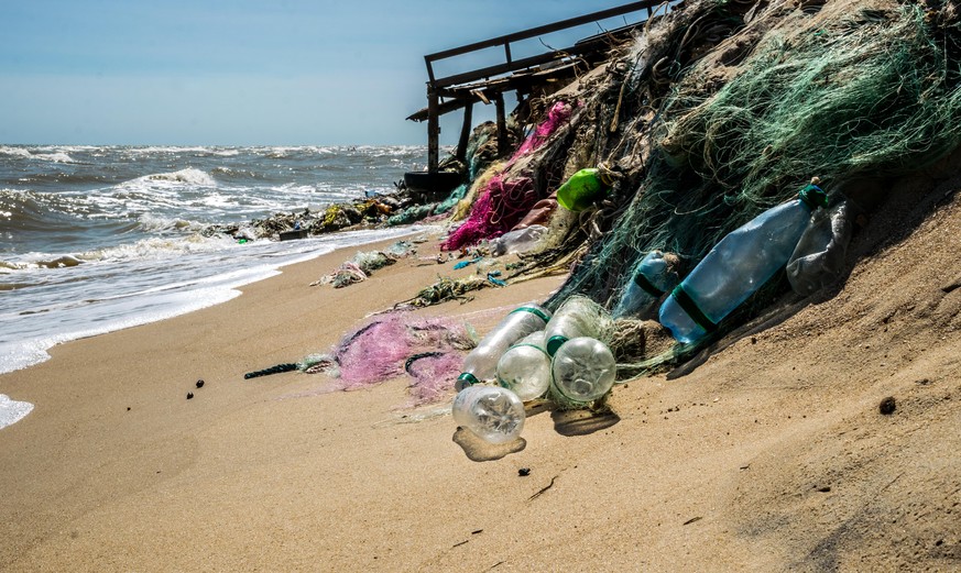 Plastic waste on a sandy beach. Pollution of the waters of the world ocean by plastic. Polluted beach in Los Angeles, USA