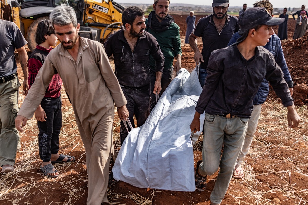 05.10.2023, Syrien, Aleppo: Menschen beerdigen die Opfer eines Raketenangriffs auf ein ziviles Haus in der Stadt Kafr Nouran. Fünf Zivilisten derselben Familie wurden getötet und weitere verletzt, nac ...