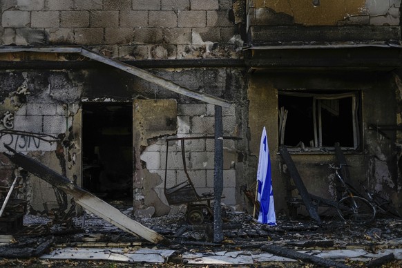ARCHIV - 22.10.2023, Israel, Be&#039;eri: Eine israelische Fahne steht neben einem von der Hamas zerstörten Haus. Der Kibbuz wurde am 7. Oktober von Mitgliedern der Hamas aus dem nahe gelegenen Gazast ...