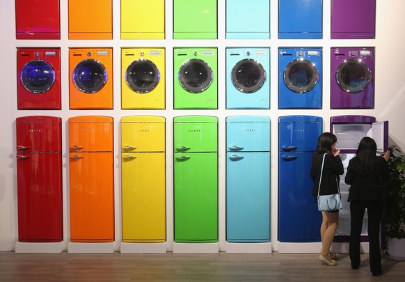 BERLIN, GERMANY - SEPTEMBER 05: Visitors look at coloured refrigerators and other appliances on display at the Vestel stand at the 2014 IFA home electronics and appliances trade fair on September 5, 2 ...
