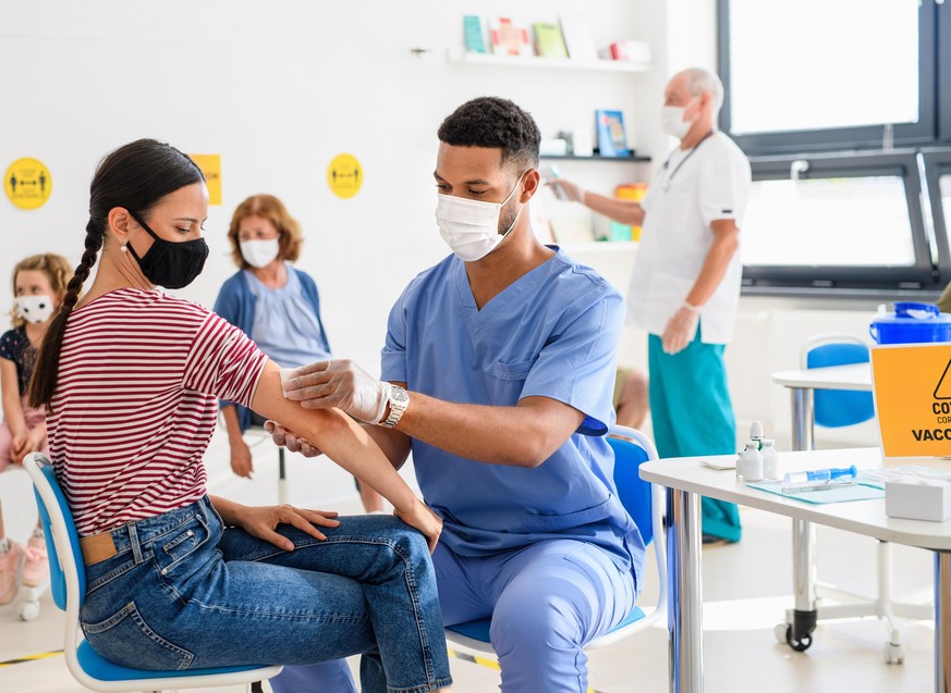 Young woman with face mask getting vaccinated, coronavirus, covid-19 and vaccination concept.