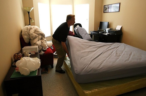 SAN FRANCISCO - APRIL 30: Pestec technician Darrell Azlin moves a bed in an apartment with bed bugs April 30, 2009 in San Francisco, California. Cases of bed bug infestations are on the rise across th ...