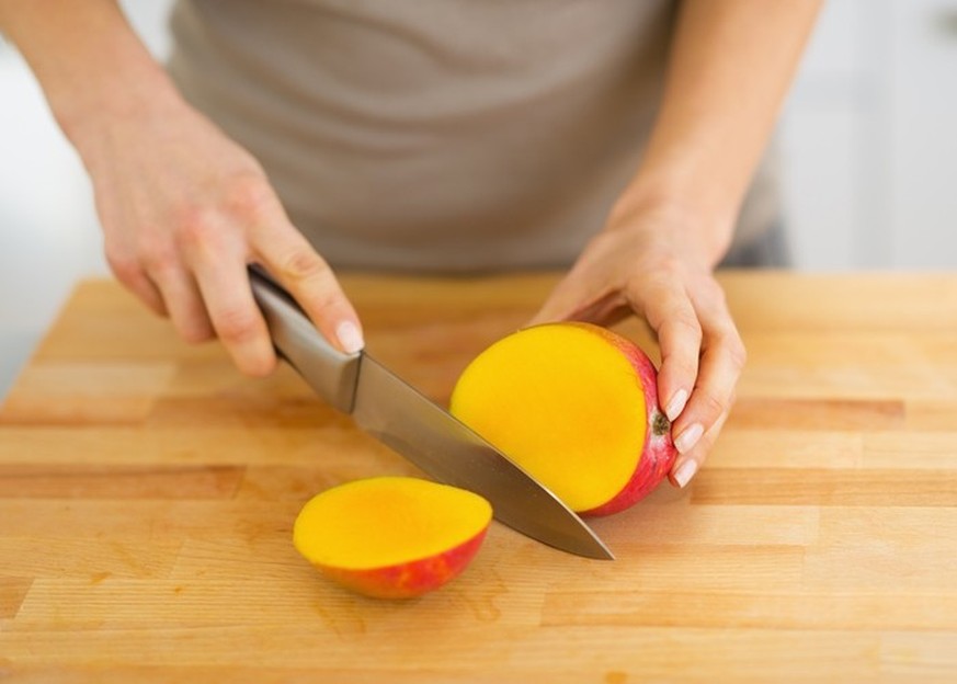 Closeup on woman cutting mango