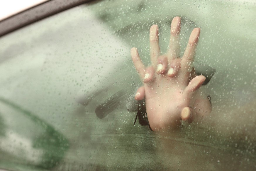 Couple holding hands having sex inside a car with a steamy window