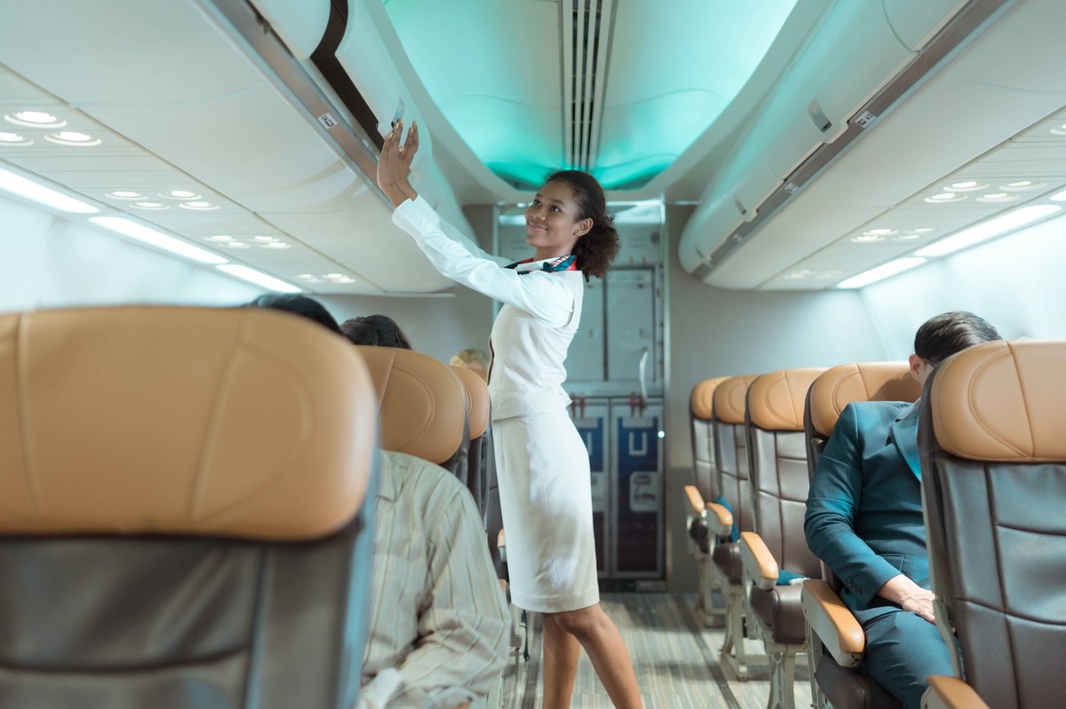 Flight attendant check the order of the passenger s luggage storage. Flight attendant check the order of the passenger s luggage storage. ,model released, Symbolfoto Copyright: xZoonar.com/SunanxWongs ...