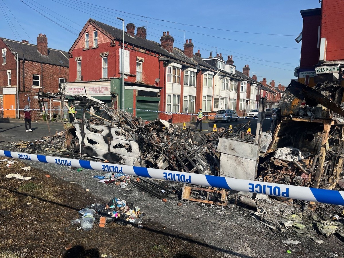 dpatopbilder - 19.07.2024, Großbritannien, Leeds: Ein ausgebranntes Auto im Vorort Harehills, nachdem Fahrzeuge in Brand gesetzt und ein Polizeiauto umgestürzt wurde. Ausschreitungen erschüttern die n ...