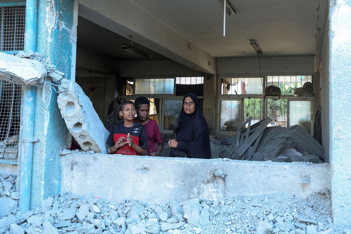 Palestinians look out of a damaged classroom at a UN school sheltering displaced people, following an Israeli strike, amid Israel-Hamas conflict, in Nuseirat in the central Gaza Strip July 16, 2024. R ...