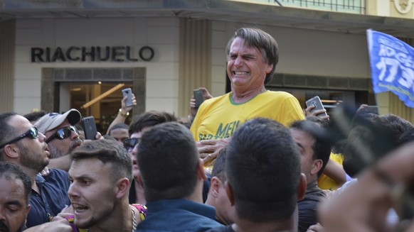 In this Sept. 6, 2018 photo, presidential candidate Jair Bolsonaro grimaces right after being stabbed in the stomach during a campaign rally in Juiz de Fora, Brazil. Bolsonaro, a leading presidential  ...