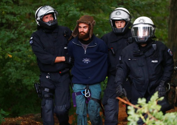 Policemen arrest an activist as they attempt to clear the area at the &quot;Hambacher Forst&quot; in Kerpen-Buir near Cologne, Germany, September 13, 2018, where protesters have built a camp with tent ...
