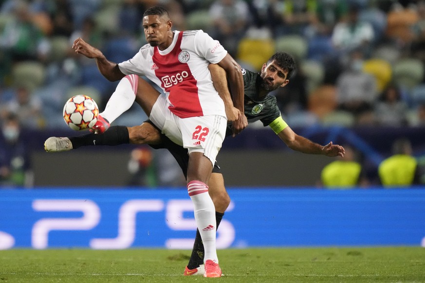 Ajax's Sebastien Haller, left, is challenged by Sporting's Luis Neto during a Champions League, Group C soccer match between Sporting CP and Ajax at the Alvalade stadium in Lisbon, Wednesday, Sept. 15 ...