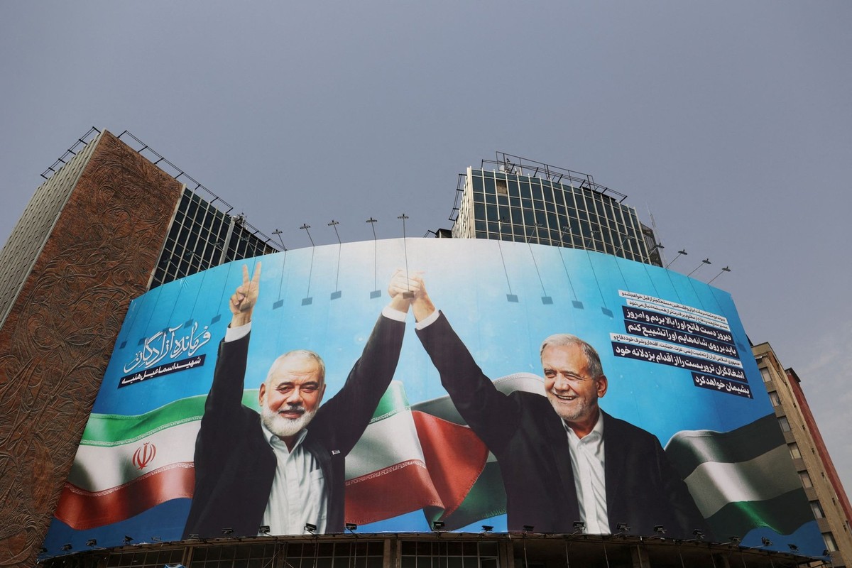 FILE PHOTO: A billboard with a picture of assassinated Hamas chief Ismail Haniyeh and Iran&#039;s President, Masoud Pezeshkian, is displayed on a building in a street in Tehran, Iran, August 1, 2024.  ...