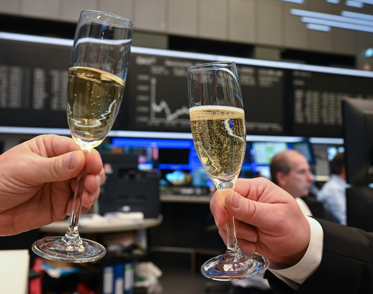 30.12.2022, Hessen, Frankfurt/Main: H�ndler sto�en am verk�rzten letzten Handelstag des Jahres auf dem Parkett der Frankfurter Wertpapierb�rse mit Sekt an. Foto: Arne Dedert/dpa +++ dpa-Bildfunk +++