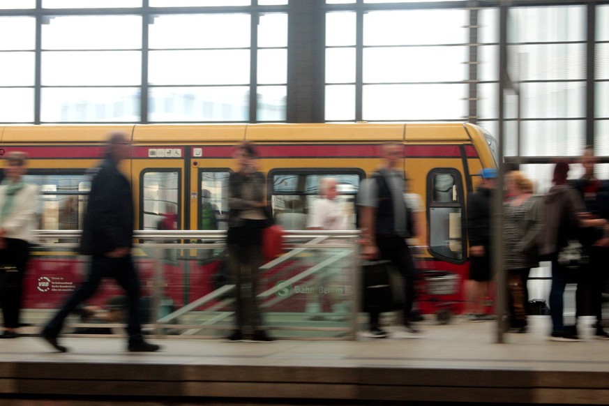 S-Bahn der Berliner Verkehrsgesellschaft BVG und DB Deutsche r Bahn bei der Einfahrt in den Bahnhof Friedrichstra