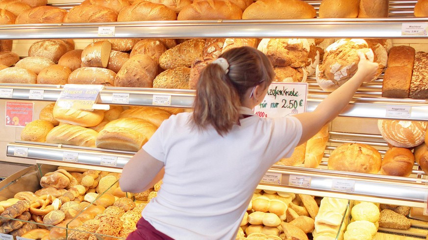 ARCHIV - Eine Verkäuferin greift am 14.03.2011 in einer Filiale einer traditionellen Bäckerei in Zwenkau (Landkreis Leipzig) nach einem Brot. (ZU dpa &quot;Bäcker zwischen Pleite und Finanzinvestoren  ...