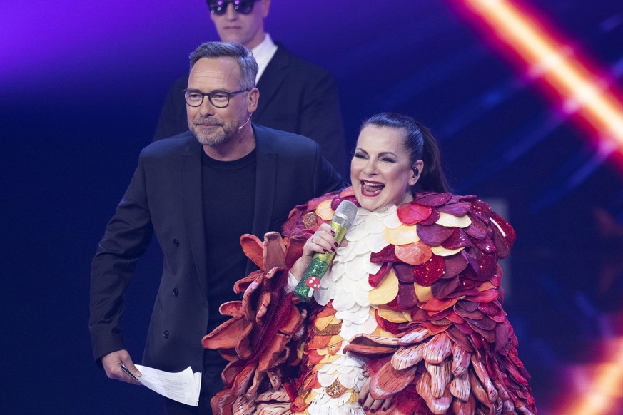 15.04.2023, Nrw, Köln: Sängerin Marianne Rosenberg, steht als Figur &quot;Der Pilz&quot; neben dem Moderator Matthias Opdenhövel in der Prosieben-Show &quot;The Masked Singer&quot; auf der Bühne. Foto ...