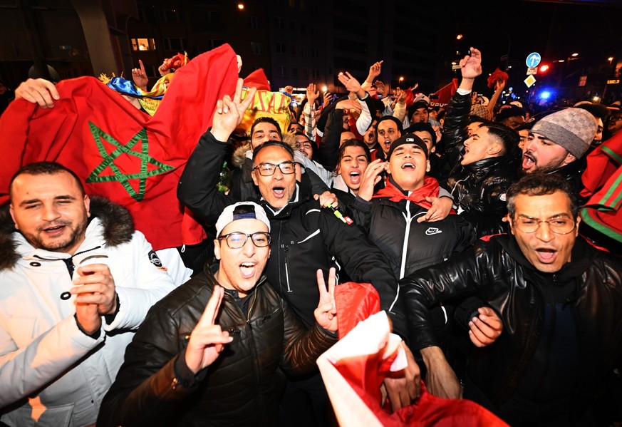 06.12.2022, Nordrhein-Westfalen, Düsseldorf: Fußball, WM, Marokko - Spanien, Finalrunde, Achtelfinale. Marokko-Fans feiern auf den Strassen von Düsseldorf nachdem sich ihre Nationalmannschaft bei der  ...