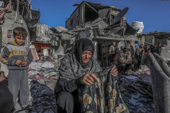 18.01.2024, Palästinensische Gebiete, Rafah: Eine Palästinenserin weint, als sie nach einem israelischen Luftangriff auf ein Haus im südlichen Gazastreifen die Schäden begutachtet. Foto: Abed Rahim Kh ...