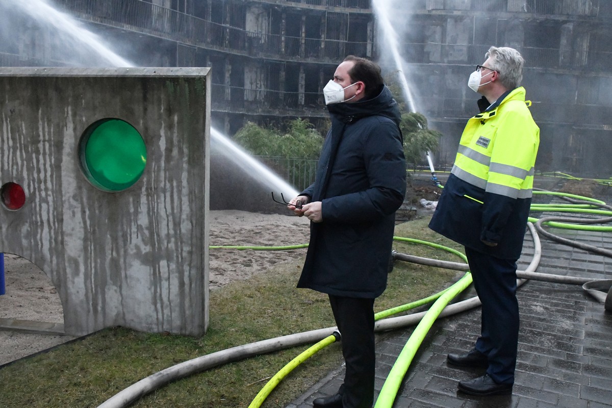 21.02.2022, Nordrhein-Westfalen, Essen: Der Oberb�rgermeister der Stadt Essen, Thomas Kufen (CDU l), und Feuerwehrdezernent Christian Kromberg besichtigen einen ausgebrannten Wohnkomplex. Im Westviert ...