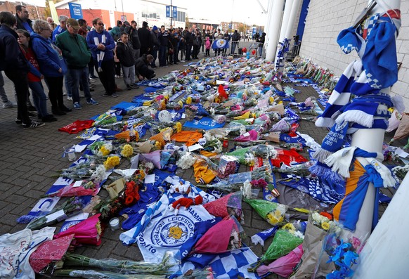 Leicester City football fans pay their respects outside the football stadium, after the helicopter of the club owner Thai businessman Vichai Srivaddhanaprabha crashed when leaving the ground on Saturd ...