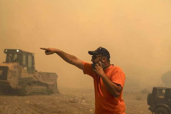 25.07.2023, Griechenland, Rhodos: Ein Freiwilliger Helfer gibt während eines Waldbrandes im Dorf Vati Anweisungen. Starke Winde erschweren den Kampf gegen die Waldbrände auf der griechischen Ferienins ...