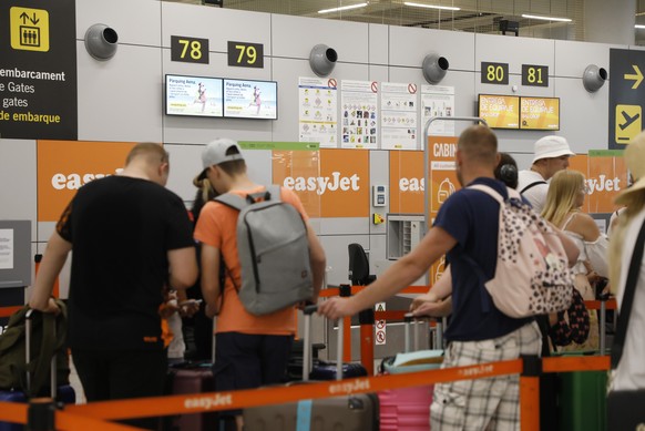 16.07.2022, Spanien, Palma: Reisende warten am Flughafen am Schalter der Fluggesellschaft Easyjet auf die Gep�ckaufgabe. Am Wochenende (16./17.07.2022) werden auf dem Flughafen von Mallorca mehr Fl�ge ...