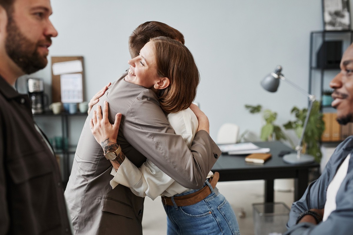 Young business people embracing and talking to each other during networking at the office