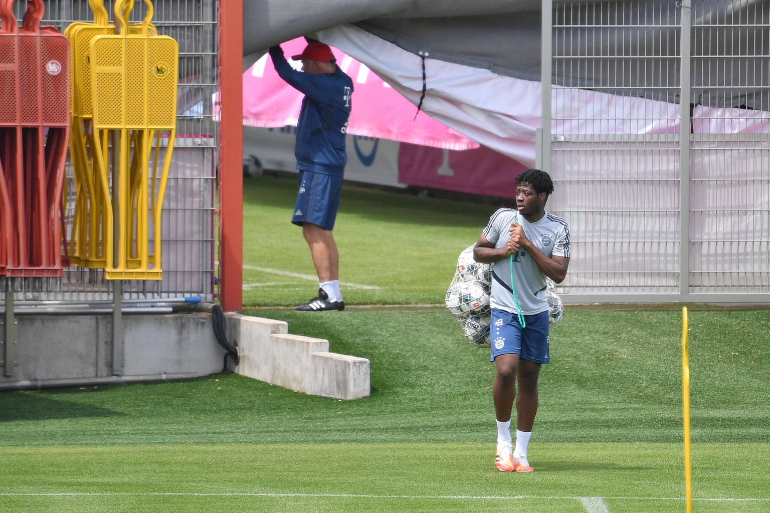 Bright Akwo Arrey-Mbi traegt ein Netz mit Baellen. FC Bayern Muenchen Training in der Coronavirus Pandemie. Training an der Saebener Strasse. Fussball 1. Bundesliga,Saison 2019/2020, am 03.06.2020 *** ...