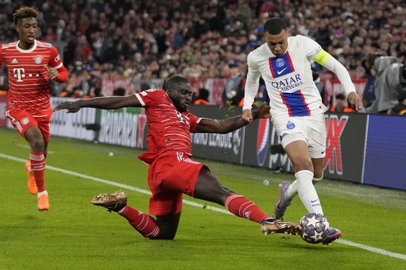 PSG&#039;s Kylian Mbappe, right, is challenged by Bayern&#039;s Dayot Upamecano during the Champions League round of 16 second leg soccer match between Bayern Munich and Paris Saint Germain at the All ...