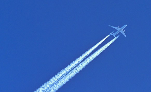 ARCHIV - 03.03.2021, Brandenburg, Neuzelle: Am blauen Himmel fliegt ein Flugzeug und hinterlässt Kondensstreifen. Aus dem Verkauf von Kohlendioxid-Verschmutzungsrechten sind Deutschland 2022 rund 13,2 ...