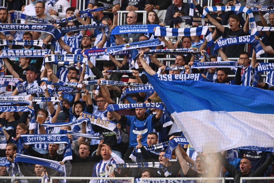 Fußball: Bundesliga, RB Leipzig - Hertha BSC, 6. Spieltag, in der Red Bull Arena. Fans vom Hertha BSC halten vor dem Spiel auf der Tribüne Hertha-Schals hoch. WICHTIGER HINWEIS: Gemäß den Vorgaben der ...