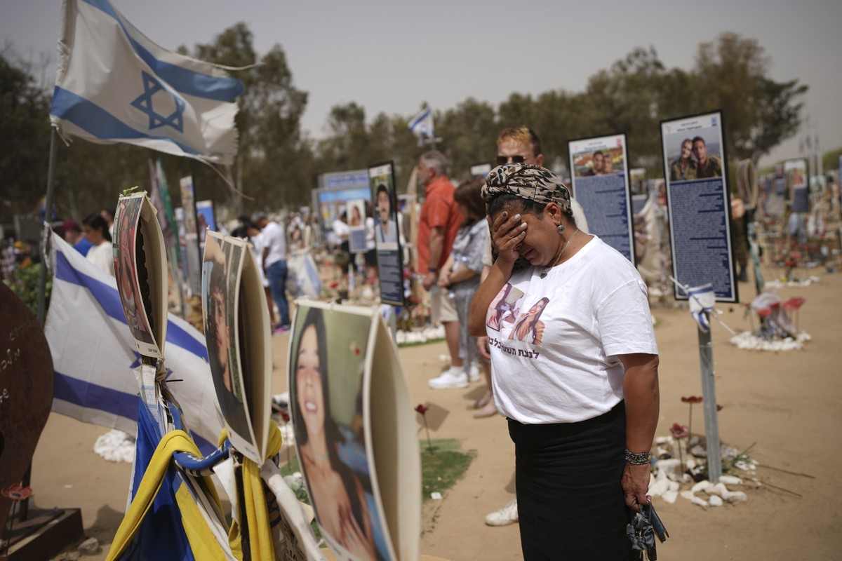 dpatopbilder - 30.04.2025, Israel, Kibbuz Reim: Menschen stehen still, um zwei Schweigeminuten einzuhalten, während Luftschutzsirenen ertönen, um den jährlichen israelischen Gedenktag am Ort des Angri ...