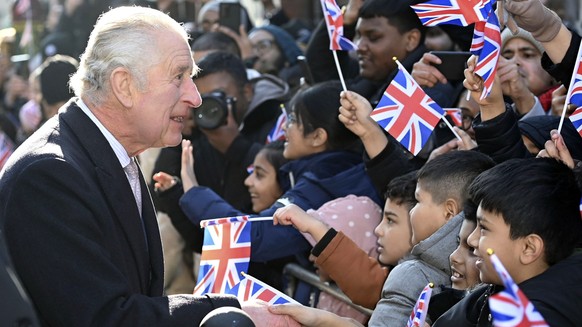 dpatopbilder - 08.02.2023, Großbritannien, London: König Charles III. begrüßt Kinder, während er und die Königsgemahlin die Brick Lane im Osten Londons besuchen, um sich mit Wohltätigkeitsorganisation ...