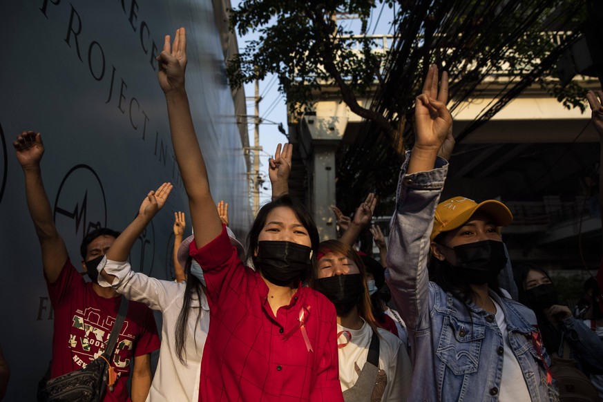 February 7, 2021, Thailand: Myanmar citizens hold up the three-finger salute outside the Embassy of Myanmar, during a protest against the Myanmar military coup, in Bangkok, Thailand, on Sunday, Februa ...