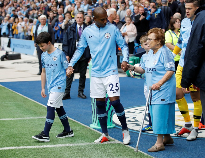 Soccer Football - Premier League - Manchester City v Fulham - Etihad Stadium, Manchester, Britain - September 15, 2018 Manchester City&#039;s Fernandinho walks out with mascot Olga Halon (L) before th ...