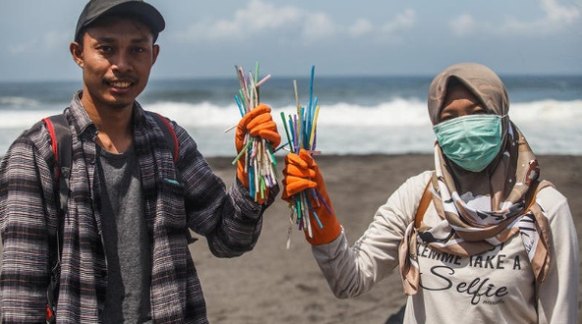 Müllsammler an einem Strand in Indonesien mit Massen von Plastikstrohhalmen. Diese Funde lassen sich keinem Unternehmen zuordnen, zeigen aber den Sinn von Verboten wie die EU gerade eines beschlossen  ...