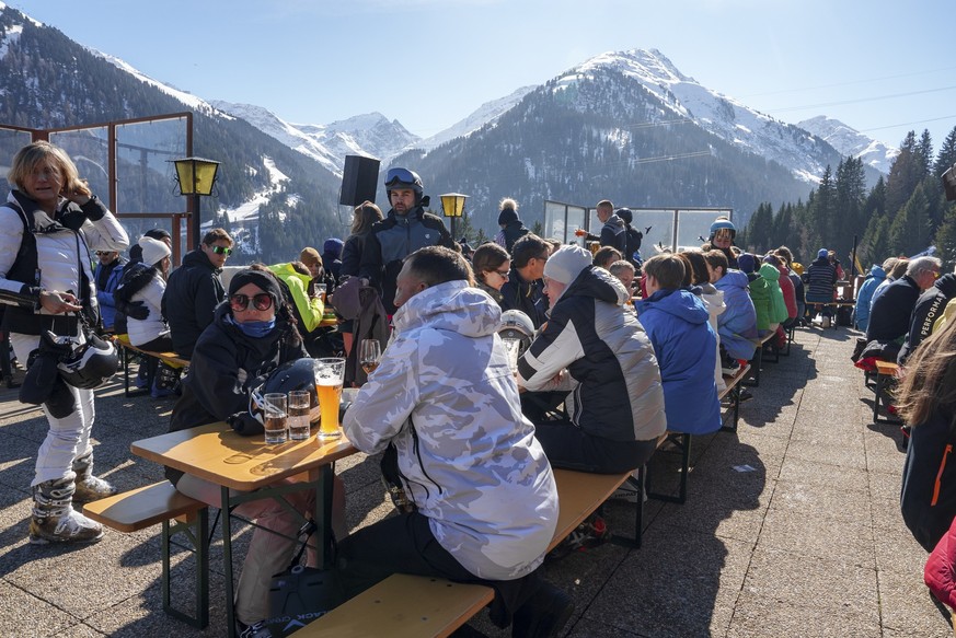Male and female tourists in warm clothing having meal at ski resort on sunny day, winter holiday travel concept xkwx Alps, Austria, Beer, Snow, adventure, alpine, arlberg, beverage, cold, destination, ...